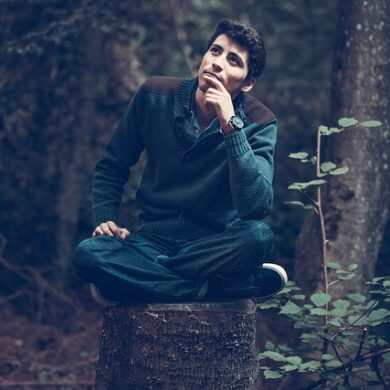 Ragazzo pensieroso seduto su un tronco
