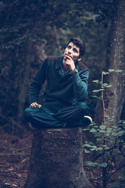 Ragazzo pensieroso seduto su un tronco